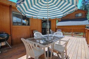 a table and chairs with an umbrella on a deck at Villa Bossi in Carnelian Bay