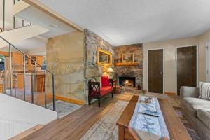 a living room with a stone wall and a fireplace at Cozy Bear's Lair in Tahoe City