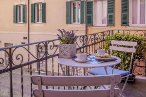 a table with two chairs and coffee cups on a balcony at Bilocale affacciato sul budello a 30 mt dal mare in Laigueglia