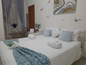 a bedroom with a large white bed with towels on it at Falanga Family Guests Accommodation in Civitavecchia