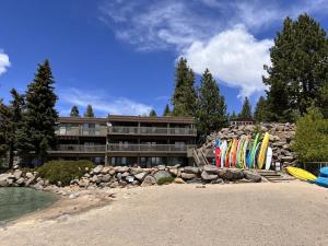 a pile of surfboards on the beach in front of a building at Beach-N-Ski Condo in Tahoe Vista