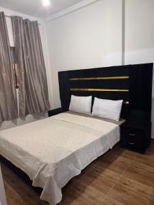 a bedroom with a large bed with a black headboard at Dar yasmine in Azrou