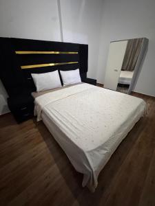 a bedroom with a large bed with a black headboard at Dar yasmine in Azrou