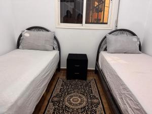 two beds sitting next to each other in a room at Dar yasmine in Azrou +2 photos