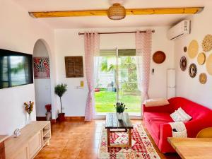 a living room with a red couch and a window at Casablanca El Petit Hotel in Deltebre