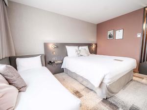 a bedroom with two beds and a couch at Mercure Bordeaux Lac in Bordeaux +125 photos