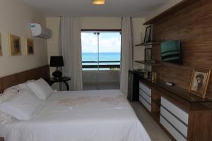 a bedroom with a bed and a television and a window at Porto Brasil Resort - Casa de praia em condomínio de luxo in Parnamirim +37 photos
