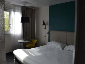 a hotel room with a bed and a table and a window at ibis Chambery in Chambéry +65 photos