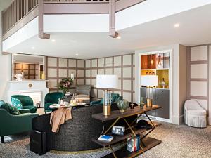 a living room with a couch and a table at Sofitel Le Scribe Paris Opera in Paris