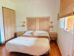 a bedroom with a bed with a headboard and a window at Casablanca El Petit Hotel in Deltebre