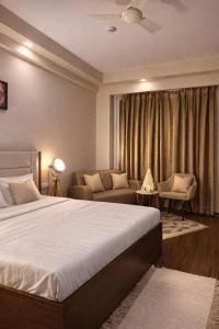 a hotel room with a bed and a couch at StayScape studio in Greater Noida