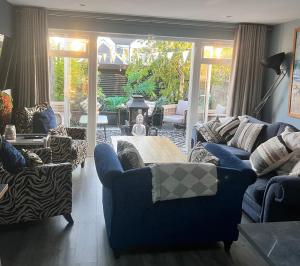 a living room with blue couches and a table at Sandy feet retreat in Exmouth