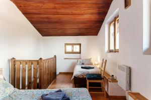 a room with two beds and a wooden ceiling at Chalet Tessa BELLAGIO in Bellagio