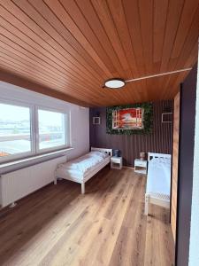 a bedroom with a bed and a wooden ceiling at Gästehaus GAP in Dietlingen