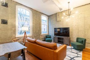 a living room with a couch and a tv at The Saint Clair in Frankfort