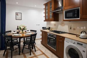 a kitchen with a table with chairs and a stove at Štúr Apartment Michalská in Bratislava +4 photos