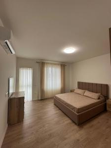 a bedroom with a large bed and a wooden floor at Olivea Suites Tirana in Tirana