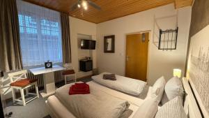 a room with two beds and a desk in it at City B&B Cochem in Cochem