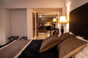 a bedroom with a bed with pillows on it at Mansión del Cobre Hotel Boutique in Los Mochis