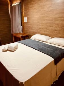 a bedroom with a large bed with two towels on it at Pousada Serena - Alter do Chão in Santarém