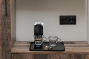 a coffee maker and two glasses on a table at Phos Luxury Living in Sarti