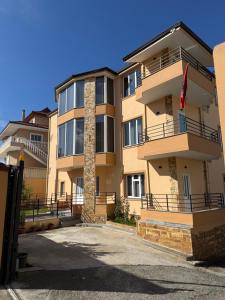 a large apartment building with a flag in front of it at Olivea Suites Tirana in Tirana