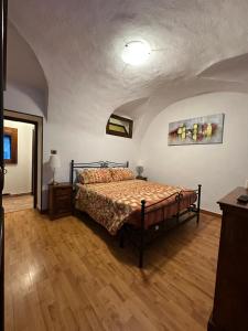 a bedroom with a bed and a wooden floor at Il Dolce Rustico in Dolceacqua