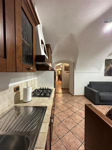 a kitchen with a stove and a couch in a room at Il Dolce Rustico in Dolceacqua