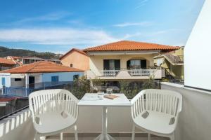 a white table and two chairs on a balcony at Phos Luxury Living in Sarti