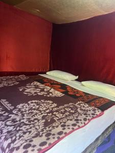 a bedroom with two beds and a red wall at Traditional nomad camp in Merdani