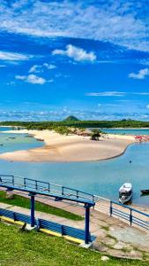 a boat in the water next to a beach at Pousada Serena - Alter do Chão in Santarém