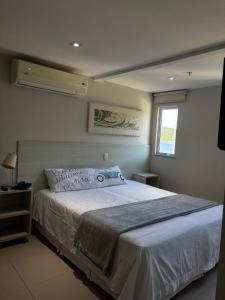 a bedroom with a large white bed with a window at Apart Itacuruçá - Hotel Porto Marina in Mangaratiba +24 photos
