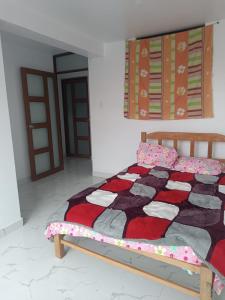 a bedroom with a bed with a quilt on it at Casa Blanca in Ayacucho