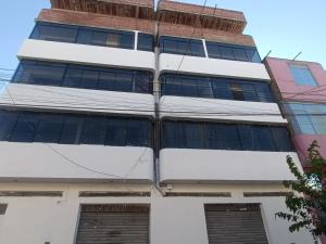 a tall white building with windows at Casa Blanca in Ayacucho