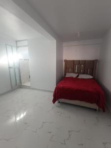a bedroom with a bed with a red blanket at Casa Blanca in Ayacucho