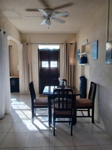 a dining room with a table and chairs and a ceiling fan at Cozy Suite, Wifi, Ac in Bedroom & 1 Minute Walk to West Coast Beach! in Saint James