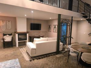 a living room with a white couch and a fireplace at Hacienda La Celada CARMONA SEVILLA in La Celada