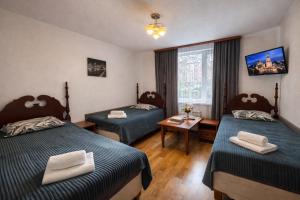 a hotel room with two beds and a window at Gusarskiy Hotel and Apartment in Kyiv