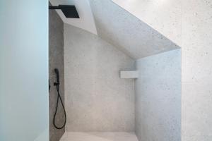 a bathroom with a shower with a shower head at Hibiscus Suites in Potos