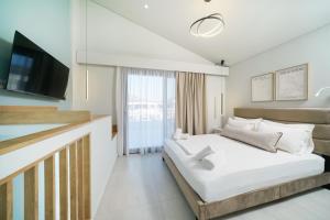 a bedroom with a large bed and a television at Hibiscus Suites in Potos