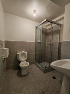 a bathroom with a shower and a toilet and a sink at York Hostel in La Paz