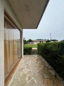 a room with a window and a stone walkway at Villa Apollonia Guest House in Fier