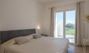 a bedroom with a large bed and a large window at Casa MILLY in Olbia