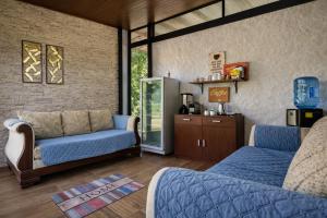 a living room with two blue couches and a kitchen at Amancay House, Jacuzzi and Pool in San Cristóbal