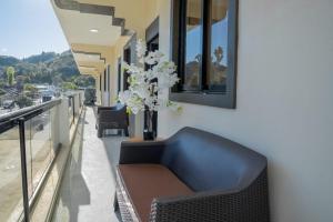 Eine blaue Couch auf einem Balkon mit einer Vase voller Blumen in der Unterkunft Hotel Bimini in Constanza