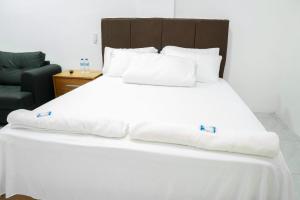 ein großes weißes Bett mit weißen Laken und Kissen in der Unterkunft Hotel Bimini in Constanza + 26 Fotos