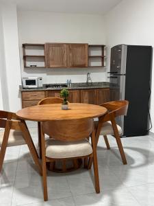 eine Küche mit einem Holztisch und einem schwarzen Kühlschrank in der Unterkunft Hotel Bimini in Constanza