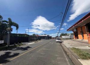 a white car parked on the side of a street at Alojamiento Cereza 1 WiFi in Alajuela
