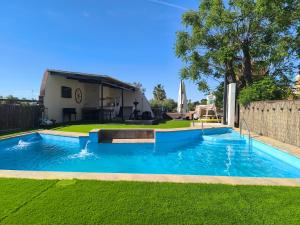 a swimming pool in a yard next to a house at Hacienda La Celada CARMONA SEVILLA in La Celada