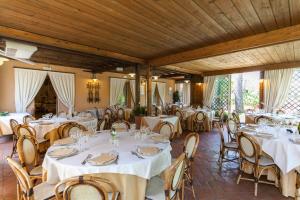 une salle à manger avec des tables et des chaises blanches dans l'établissement Locanda Antiche Macine, à Santarcangelo di Romagna